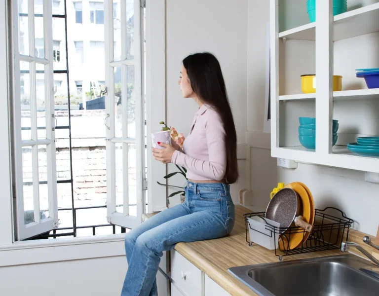 Student in dorm room looking out window