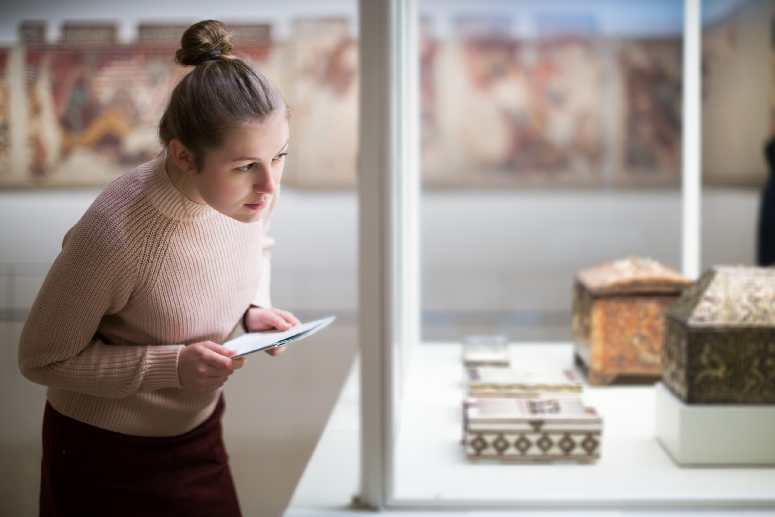 woman standing near exposition in art museum