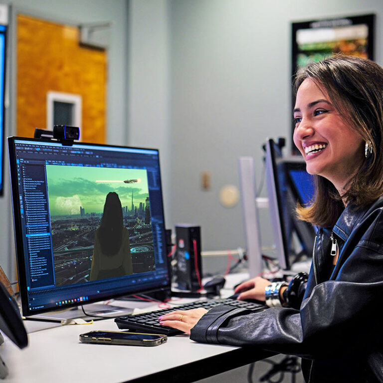 Woman working on digital art or photo editing at a computer in a creative workspace.