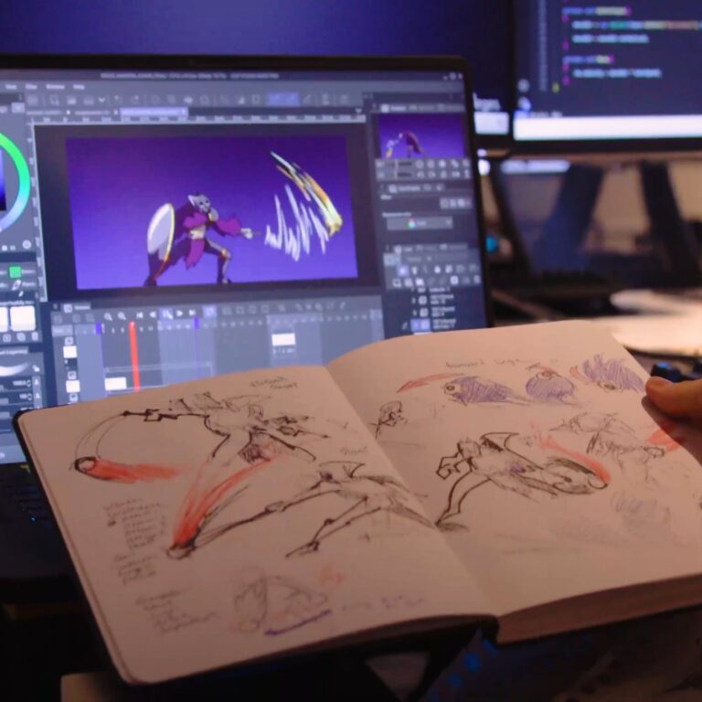 A person works on character sketches in a sketchbook while designing animated scenes on a digital drawing tablet, surrounded by multiple monitors showing animation software and code.